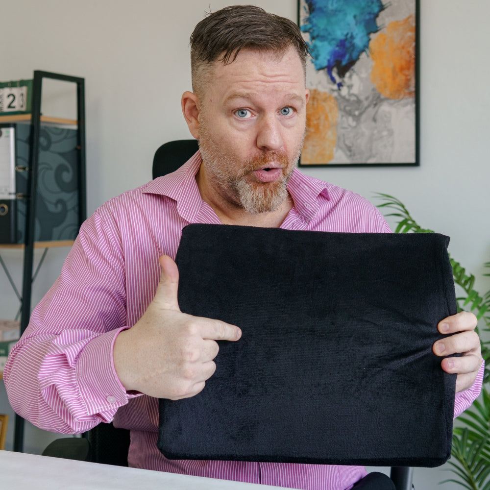 Mann som viser frem Korsryggstøtten fra Din Holdning